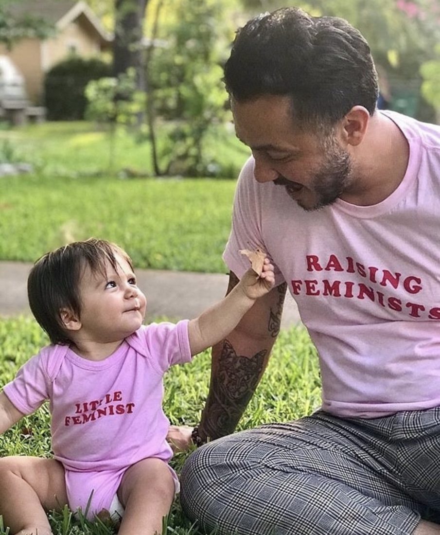 A dad in a Raising Feminists shirt with his toddler