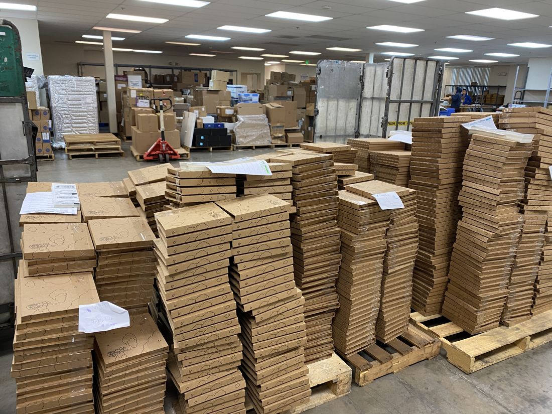 Pallets of Little Feminist boxes in the warehouse