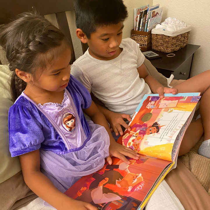 Two children reading a picture book together.