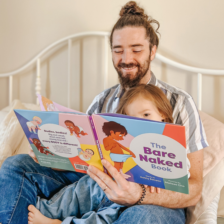 An adult and child reading The Bare Naked Book together.