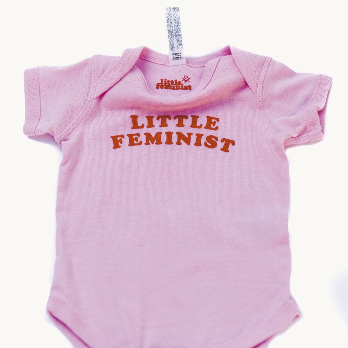 Little Feminist pink onesie inside label
