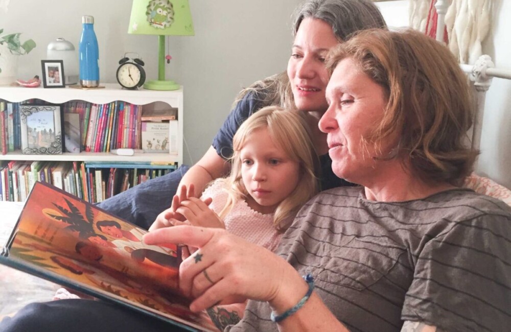 family reading book about refugees