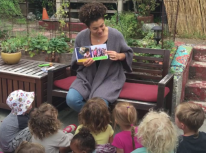 Woman reading book to a group of children